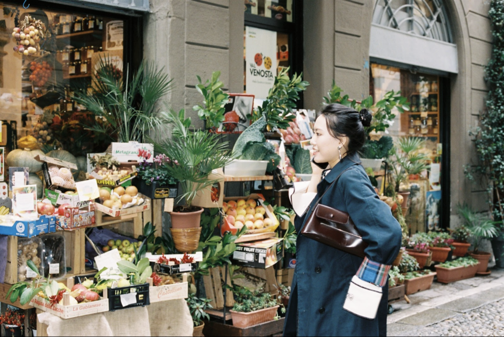 female student looking at plants at outdoor market