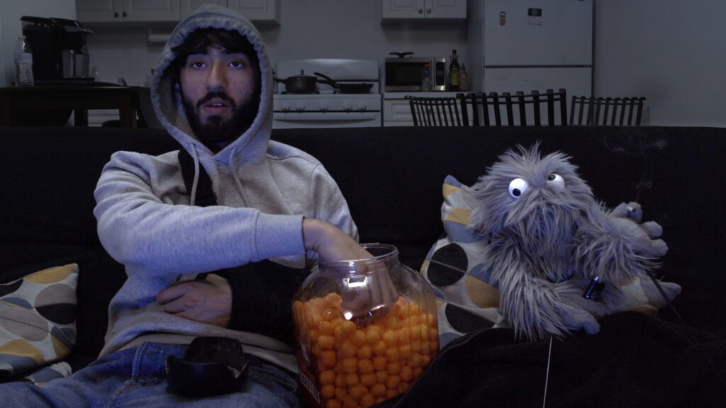 Man and puppet watching TV sitting on a couch
